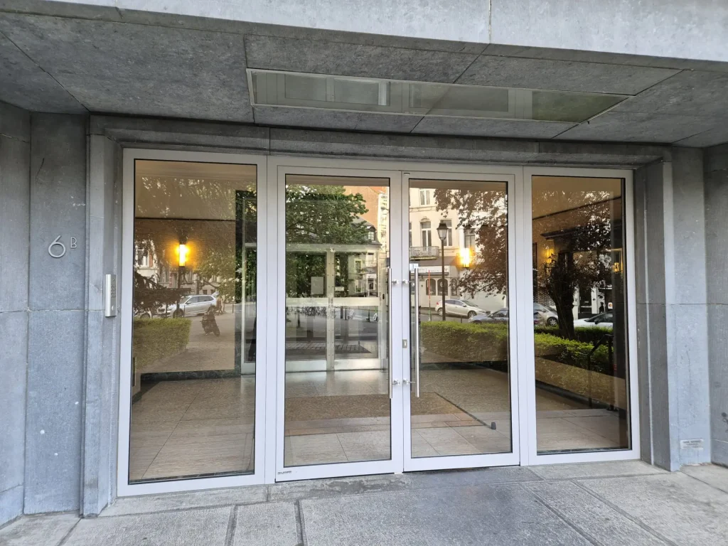 Entrée vitrée avec double porte sécurisée pour immeuble urbain