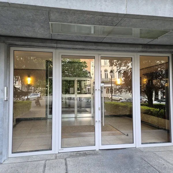 Entrée vitrée avec double porte sécurisée pour immeuble urbain