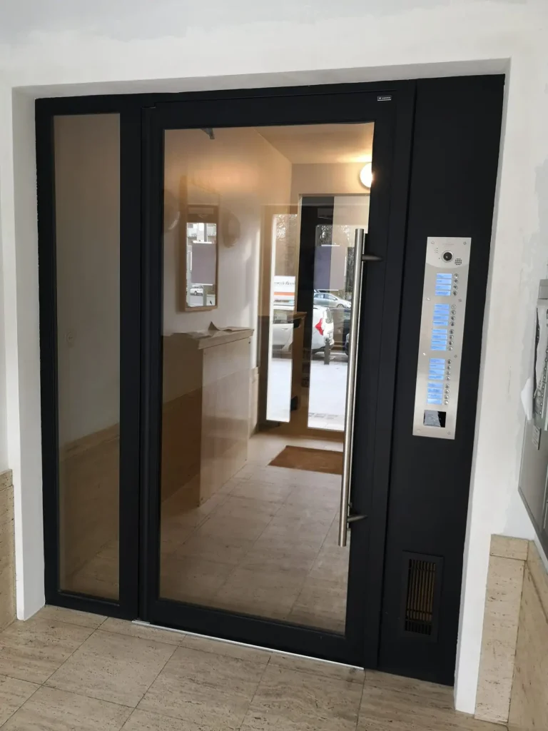 Entrée d’immeuble avec porte noire vitrée